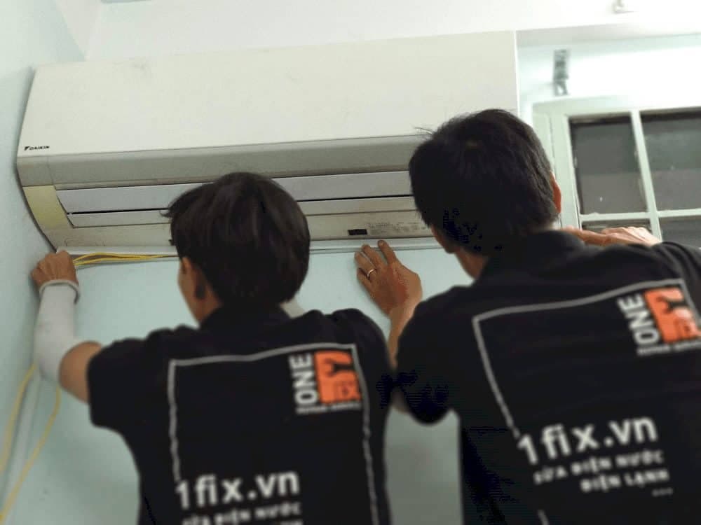 Thợ điện lạnh 1Fix đang sửa máy lạnh tại nhà khách hàng