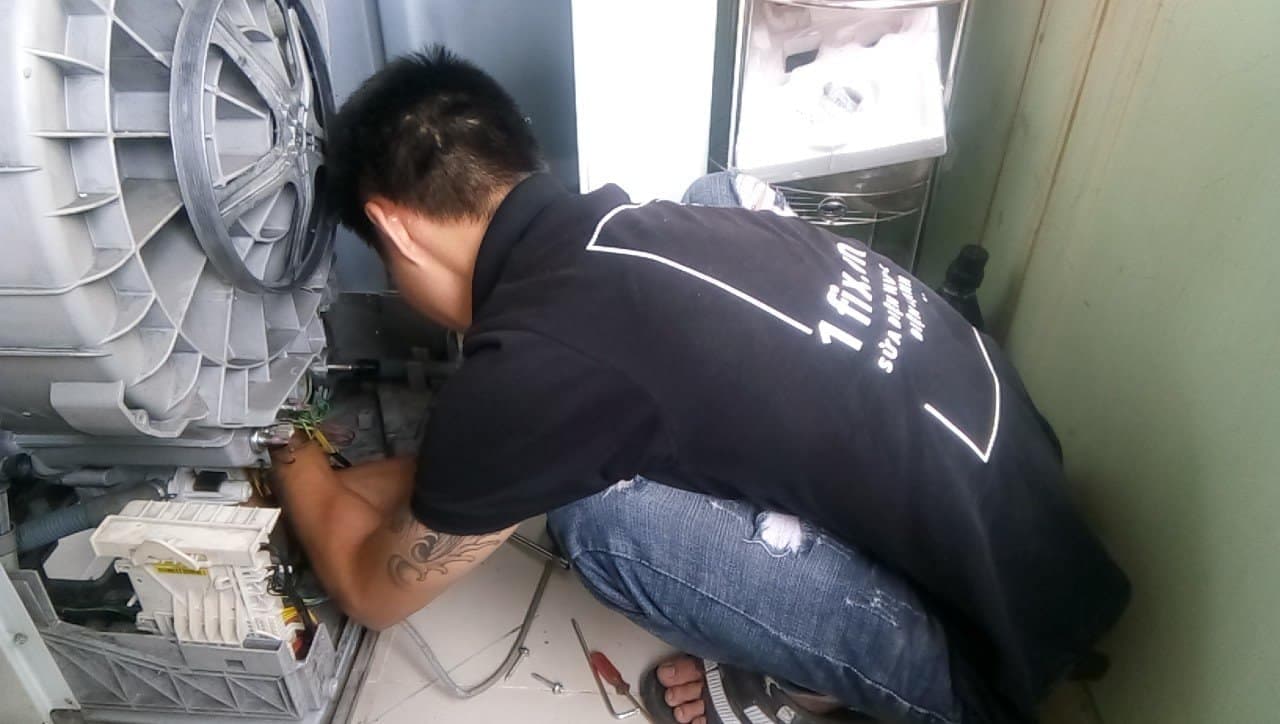 Kỹ thuật viên 1Fix đang kiểm tra bo mạch điều khiển máy giặt.