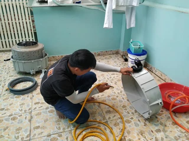 Sử dụng máy xịt rửa áp lực cao để làm sạch mọi cặn bẩn trên lồng giặt