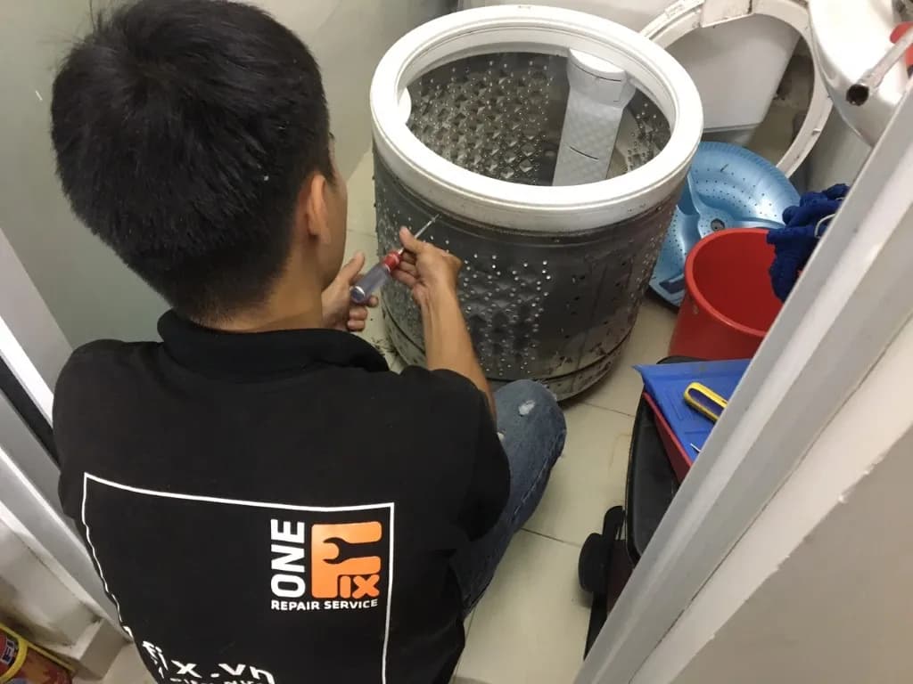Thợ kỹ thuật 1Fix đang tháo rời lồng giặt để chuẩn bị vệ sinh chuyên sâu