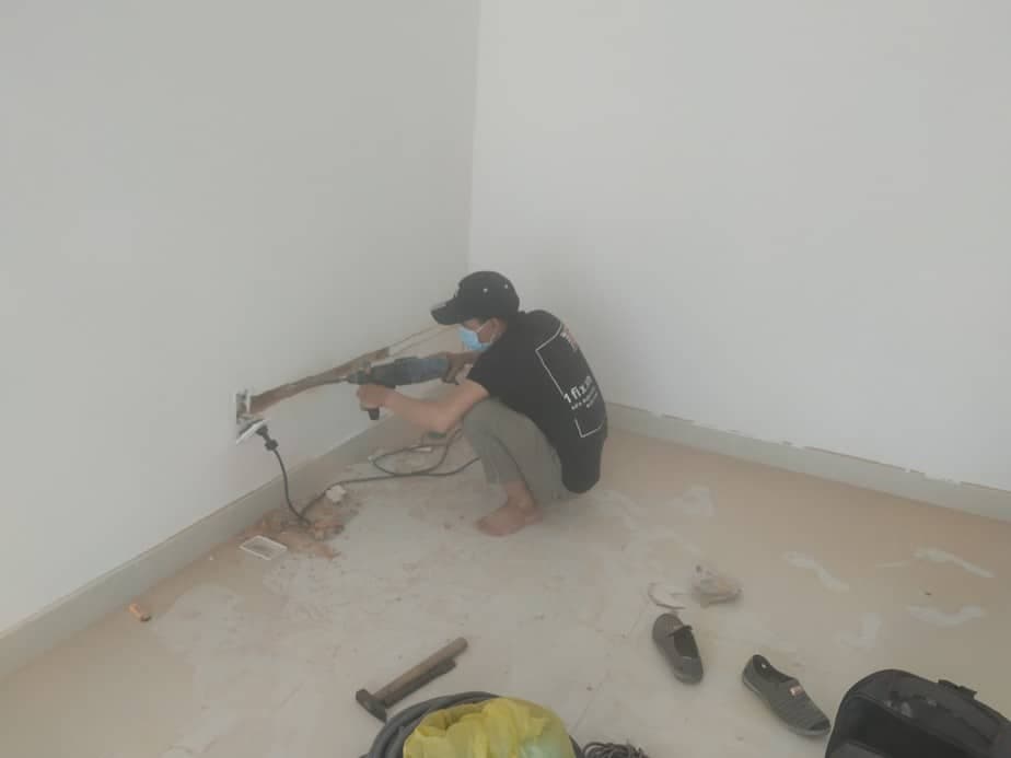 Thợ 1Fix đang thực hiện khoan tường để lắp đặt vật dụng cho khách hàng tại TPHCM.