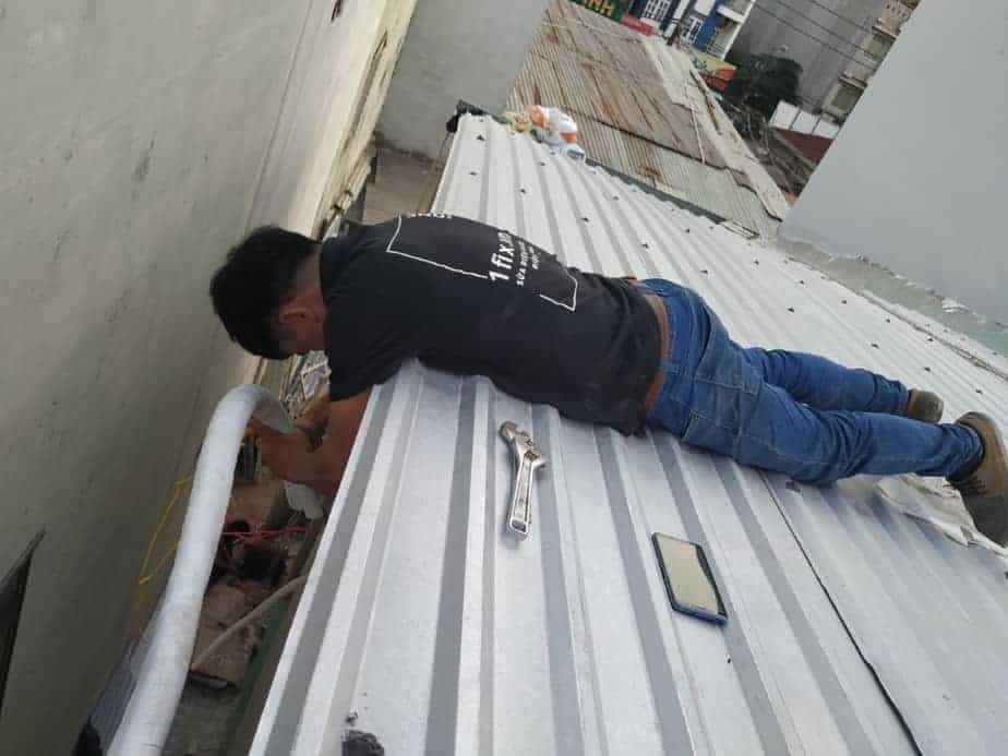 Kỹ thuật viên 1Fix đang sửa chữa dàn nóng máy lạnh treo tường.