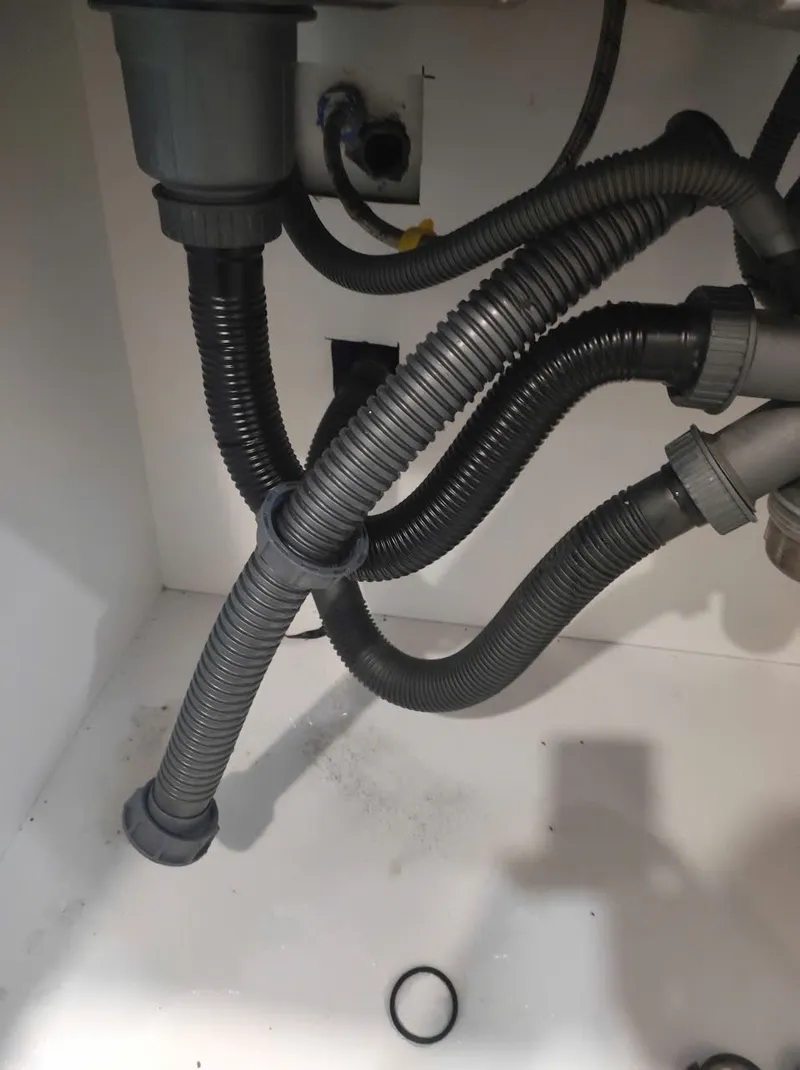 Hệ thống ống thoát nước dưới bồn rửa bị đấu nối sai, thợ 1Fix sắp xếp lại để lấy đủ độ dốc tại Thủ Đức