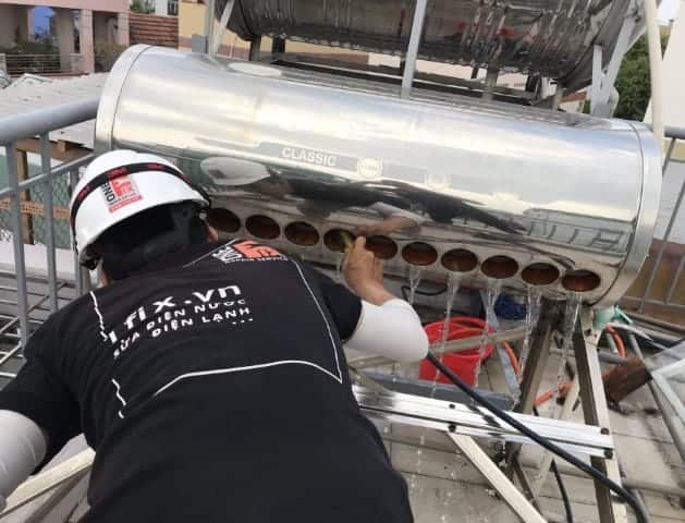 Thợ 1Fix đang vệ sinh cặn phèn bên trong bồn bảo ôn của máy nước nóng năng lượng mặt trời