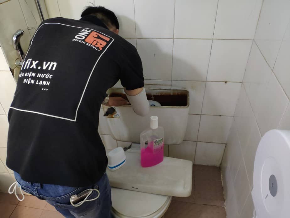 Thợ 1Fix đang siết ốc thay phao bồn cầu mới cho khách hàng tại TPHCM