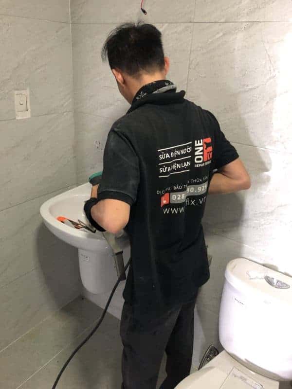 Thợ của 1Fix đang siết lại bộ xả lavabo cho khách hàng