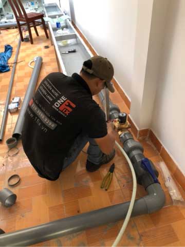Thợ 1Fix đang kiểm tra và sửa chữa đường ống nước bị rò rỉ tại nhà khách ở Sài Gòn.