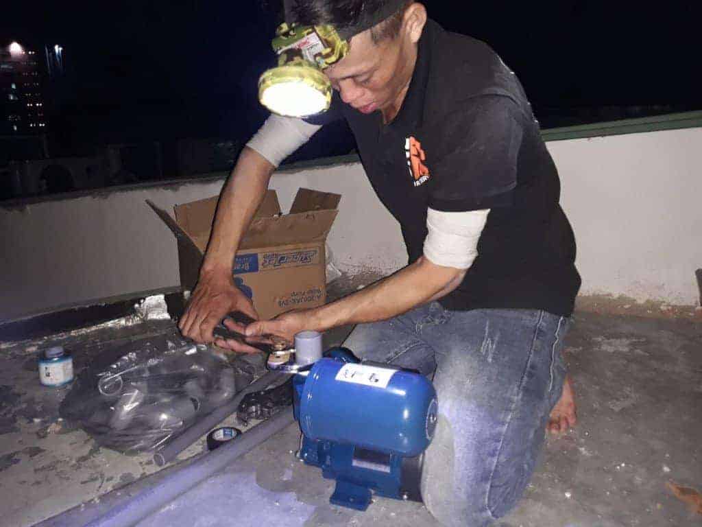 Một máy bơm tăng áp chịu nhiệt nhỏ gọn được lắp đặt gần hệ thống ống nước.