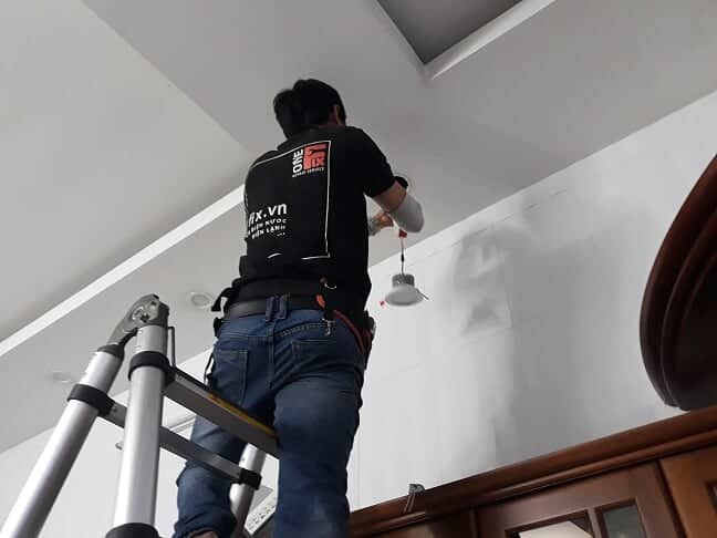 Thợ điện 1FIX đang thực hiện thay đèn LED âm trần tại nhà khách hàng ở TPHCM