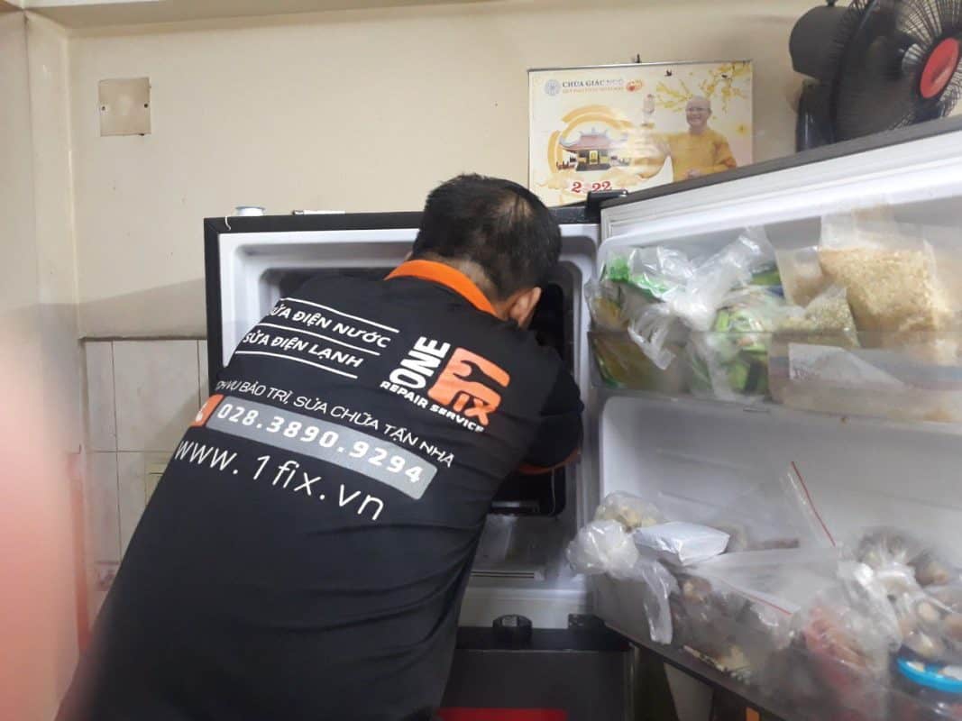 Kỹ thuật viên 1Fix đang kiểm tra hệ thống quạt gió và dàn lạnh bên trong tủ lạnh.