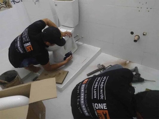 Thợ 1Fix đang thay bộ xả bồn cầu bị rò rỉ nước liên tục