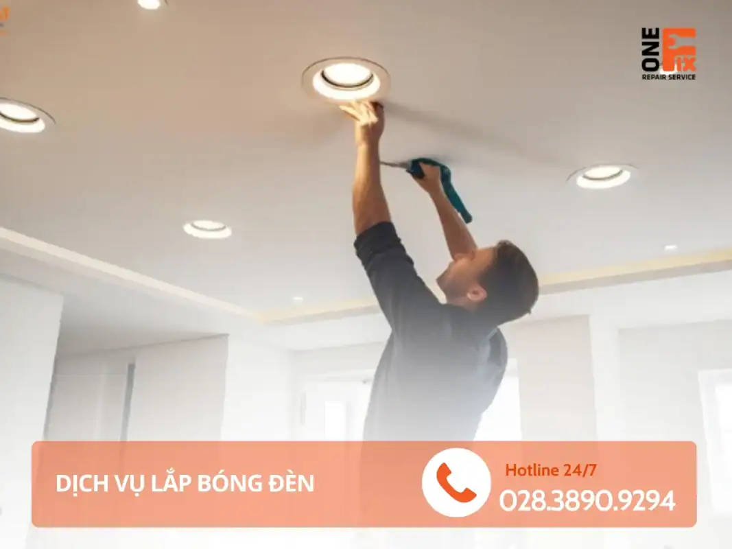 Thợ điện 1Fix đang đứng trên thang để lắp bóng đèn cho khách ở TPHCM.