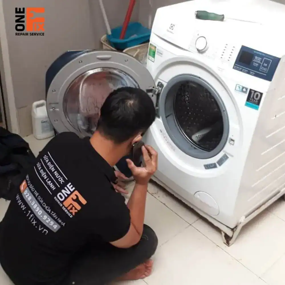 Thợ 1FIX đang lắp đặt máy giặt mới cho khách hàng tại Quận 3