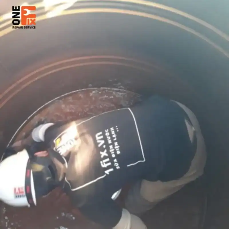 Thợ của 1Fix đang dùng máy phun áp lực cao để vệ sinh thành bồn nước inox.